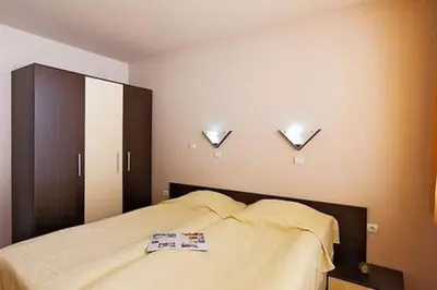 a bedroom with a bed and two lights on the wall at Apart Hotel Forest Nook 3 Pamporovo in Pamporovo