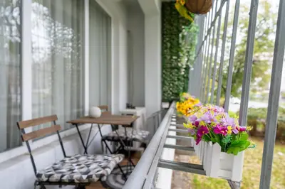 a porch with flowers and a table and chairs at Бизнес & Арт апартамент - до Панаира и Капана in Plovdiv