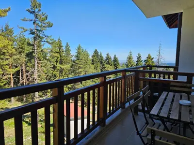 a balcony with a wooden bench and a table at Studios in Semiramida Gardens - 8,10,28 in Borovets