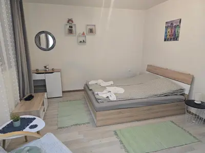 a small bedroom with a bed and a table at Peshtera Cozy Apartment in Peshtera