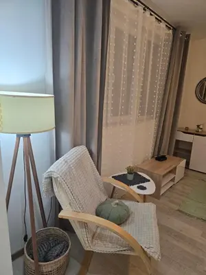 a living room with a chair and a lamp at Peshtera Cozy Apartment in Peshtera