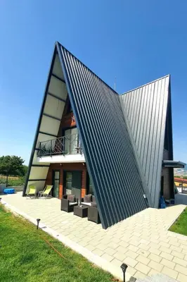 a large house with a black roof and a patio at Magnika in Sapareva Banya