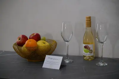 a table with a bowl of fruit and a bottle of wine at Ивелия Хотел и Спа - Ivelia Hotel & SPA in Dŭbnitsa