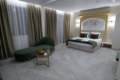 a hotel room with a bed and a chair at Ивелия Хотел и Спа - Ivelia Hotel & SPA in Dŭbnitsa