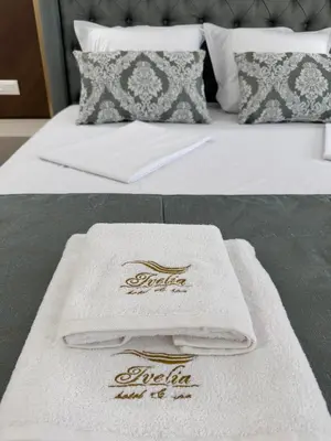 two towels sitting on top of a bed at Ивелия Хотел и Спа - Ivelia Hotel & SPA in Dŭbnitsa