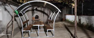 a group of wooden benches sitting under an archway at Guest Suite SUZY in Petrich