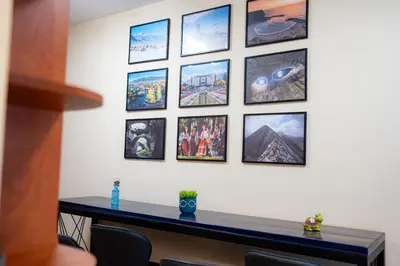 a wall of pictures on a wall with a table at 2 DeLuxe Apartments, Top Center Free Parking, 4 BDR in Sofia