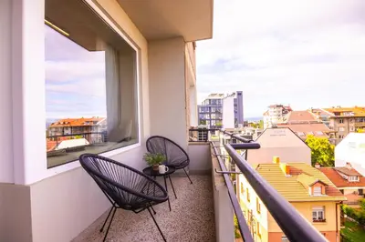 a balcony with two chairs and a view of the city at Art Retreat Zaimov in Sofia