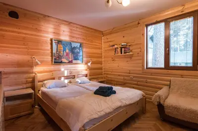 a bedroom with a bed in a wooden room at Villa Margarita 1 in Semkovo