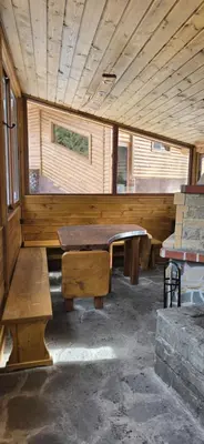 a room with a table and benches in a cabin at Villa Margarita 1 in Semkovo