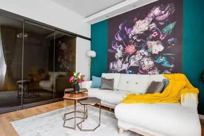 a living room with a white couch and a colorful wall at 2BR, 4 Baths, Terrace Steps from Sofia Landmarks in Sofia