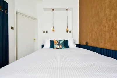 a bedroom with a large white bed with blue walls at 2BR, 4 Baths, Terrace Steps from Sofia Landmarks in Sofia