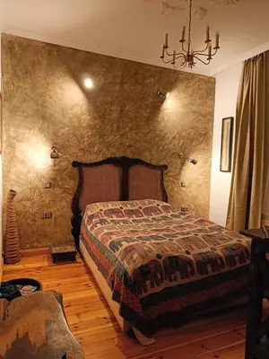 a bedroom with a bed and a stone wall at Cultural Monument residence in Doktorska Gradina in Sofia
