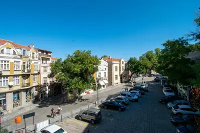 a city street with cars parked in a parking lot at Apartment Central in Plovdiv