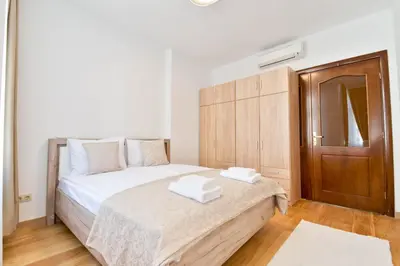 a bedroom with a bed and a wooden cabinet at Apartment Central in Plovdiv
