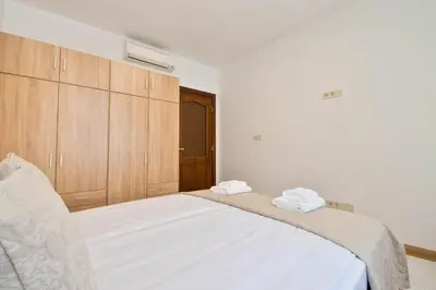 a bedroom with a large white bed with wooden cabinets at Apartment Central in Plovdiv