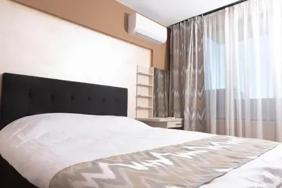 a bedroom with a large bed and a window at Apartment Maritsa View 1 in Plovdiv