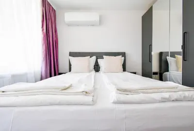 a bedroom with two beds with white sheets at Contemporary City Stay by Flat Mаnager in Sofia