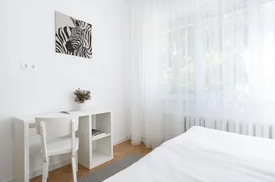 a white bedroom with a desk and a bed at Starflat Gorgeous central apartment next to NDK in Sofia