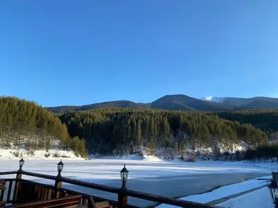 a view of a frozen lake with mountains in the background at Gondola Vibes in Bansko