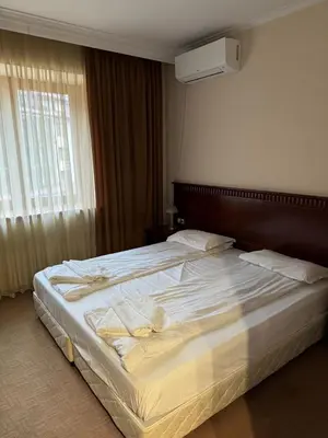 a large white bed in a bedroom with a window at Gondola Vibes in Bansko