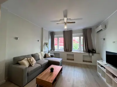 a living room with a couch and a ceiling fan at Modern 100m Apt In Sofia Center Vitosha Blvd in Sofia