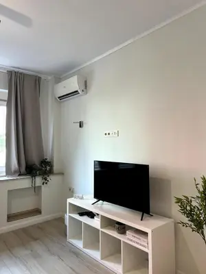 a living room with a flat screen tv on a white cabinet at Modern 100m Apt In Sofia Center Vitosha Blvd in Sofia