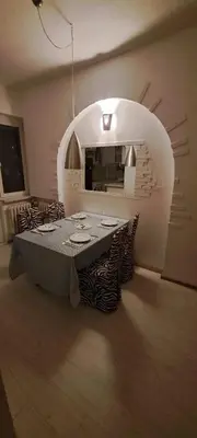 a dining room with a table in a room with an arch at Bright apartment in Doktorska gradina in Sofia