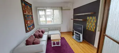 a living room with a couch and a tv at Bright apartment in Doktorska gradina in Sofia