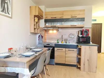 a kitchen with a dining table and a kitchen with a stove at Moderno Studio Park Lane in Bansko