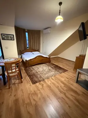 a bedroom with a bed and a table in a room at Central Mansard Studio in Sofia