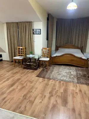 a bedroom with a bed and two chairs and a table at Central Mansard Studio in Sofia