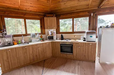 a kitchen with wooden cabinets and a refrigerator at Комплекс Родопска среща - Къщи и Апартаменти in Batak