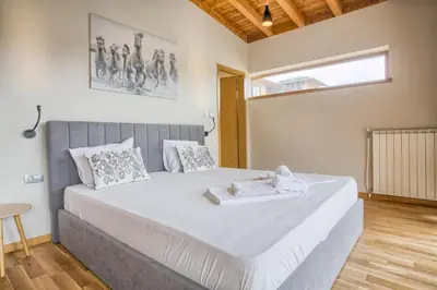 a bedroom with a large white bed in a room at Aquaterra Villa with Hot Pool - Banya in Banya