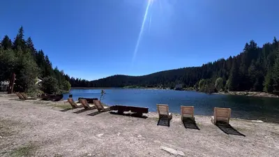 a row of chairs sitting next to a lake at Maisonette on the slope in Manastir 3 in Pamporovo