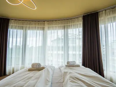 a bedroom with two beds and a large window at Venti club B15 in Sofia