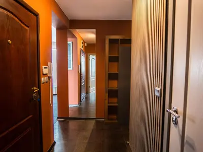 a hallway with orange walls and wooden floors and a door at Venti club B15 in Sofia