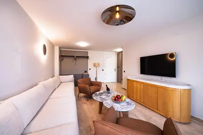 a living room with a large couch and a flat screen tv at Nik Palas Luxury Residence in Sandanski