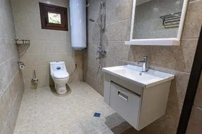 a bathroom with a toilet and a sink and a mirror at Комплекс Родопска среща - Къщи и Апартаменти in Batak