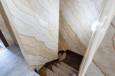 a room with a stone wall with a chair in it at Комплекс Родопска среща - Къщи и Апартаменти in Batak