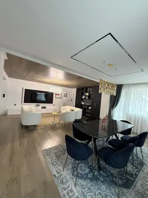 a living room with a dining room table and chairs at Grand Trio Apartment in Plovdiv