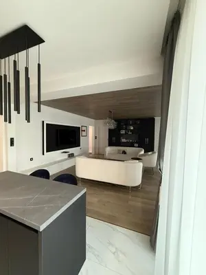 a living room with a white couch and a table at Grand Trio Apartment in Plovdiv