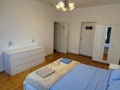 a bedroom with a large bed and a chandelier at Апартамент 36 in Sofia