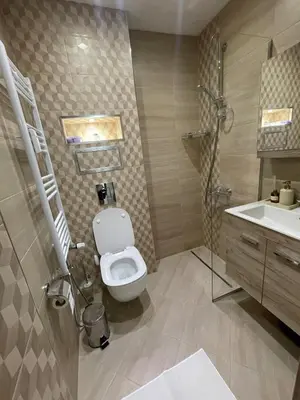 a bathroom with a toilet and a shower and a sink at Emlex Stylish Apartment in the Heart of Sofia in Sofia