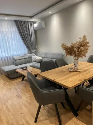 a living room with a table and a couch at Emlex Stylish Apartment in the Heart of Sofia in Sofia