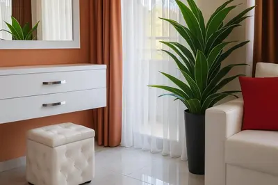 a living room with a chair and a potted plant at Парк Апарт-Хотел Виктория 1 in Sandanski