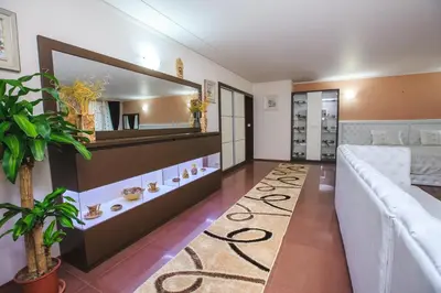 a living room with a couch and a mirror at Парк Апарт-Хотел Виктория 1 in Sandanski