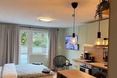 a bedroom with a bed and a kitchen with a table at Urban Hive - Central Designer Studio in Lozenets in Sofia
