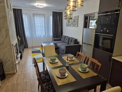 a kitchen and living room with a table and chairs at 1А1 Apartament in Pamporovo