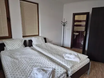 a bedroom with a large bed with white sheets at 1А1 Apartament in Pamporovo